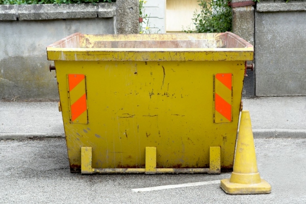 żółty kontener na śmieci stojący na chodniku